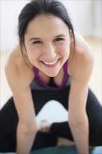 Caucasian woman smiling on yoga mat