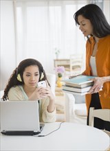 Mother bringing homework to busy daughter