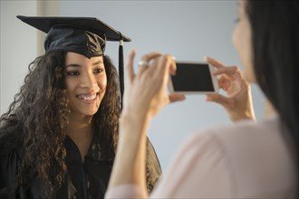 Mother photographing daughter at graduation