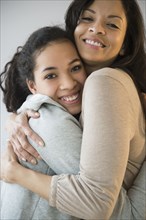 Smiling mother and daughter hugging