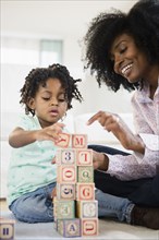 Mother and daughter playing with wooden blocks