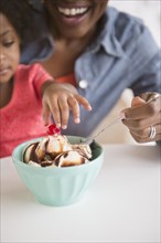 Mother and daughter eating ice cream sundae