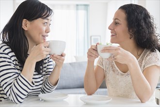 Women drinking coffee together at table