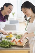 Women chopping vegetables together