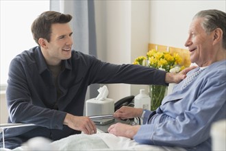 Caucasian son visiting father in hospital