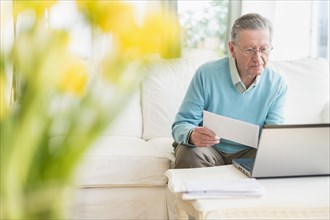 Senior Caucasian man paying bills online