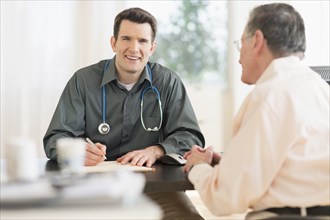 Caucasian doctor and patient talking in office