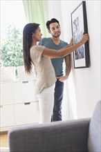 Couple hanging picture together