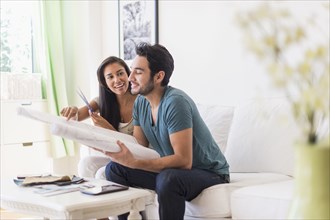 Couple examining blueprints in living room
