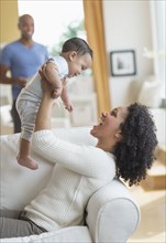 Mixed race mother playing with baby on sofa
