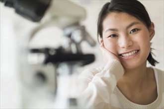 Mixed race teenage girl smiling in science lab