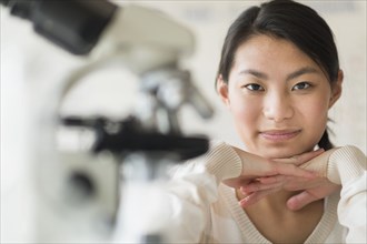 Mixed race teenage girl smiling in science lab