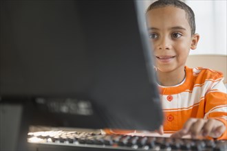 Mixed race boy using computer