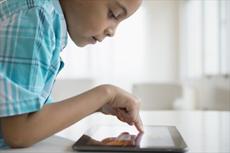 Mixed race boy using tablet computer
