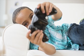 Mixed race boy playing video games