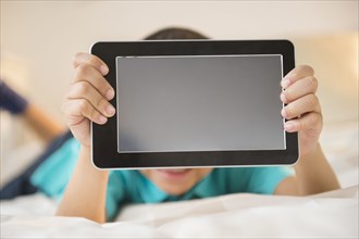 Mixed race boy holding tablet computer