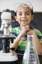 Mixed race boy doing experiments in science class