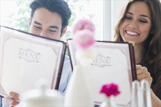 Couple reading menus in restaurant