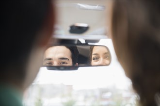 Couple admiring themselves in rearview mirror