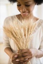 African American woman holding bunch of wheat