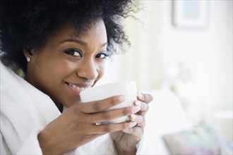 African American woman drinking cup of coffee