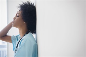 African American nurse leaning against wall
