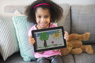 African American girl showing drawing on tablet computer