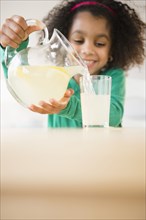 African American girl pouring glass of lemonade