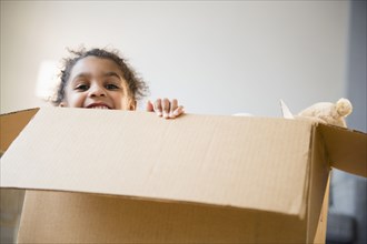 African American girl playing in cardboard box