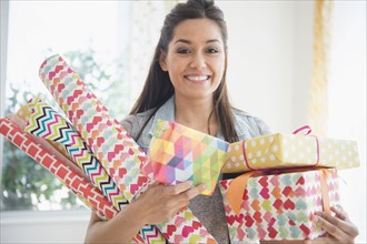 Woman carrying wrapping paper and gifts