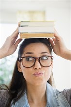 Woman balancing stack of books on her head