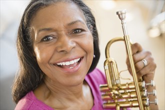 Mixed race woman holding trumpet