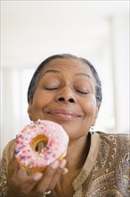 Mixed race woman eating donut
