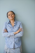 Mixed race woman standing with arms crossed