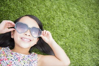 Filipino girl wearing sunglasses in backyard