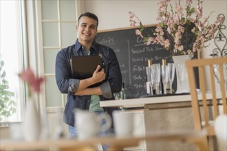 Hispanic waiter smiling in cafe