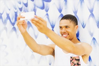 African American man taking cell phone pictures