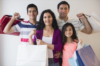 Hispanic family holding shopping bags together