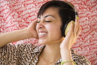 Mixed race woman listening to headphones