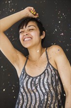 Smiling mixed race woman dancing in confetti