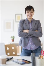 Mixed race businesswoman smiling at office desk