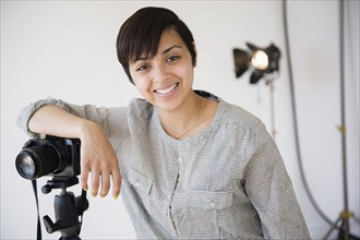 Mixed race photographer smiling in studio