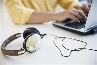 Mixed race man using laptop with headphones