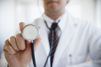 Close up of mixed race doctor holding stethoscope