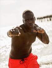Mixed race man training on beach