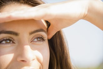 Close up of Caucasian woman shielding eyes from sun