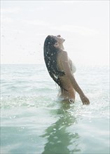 Caucasian woman wading in ocean