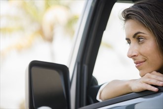 Caucasian woman leaning on car window