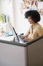 Businesswoman working at computer in cubicle