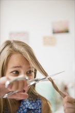 Caucasian girl cutting her own hair